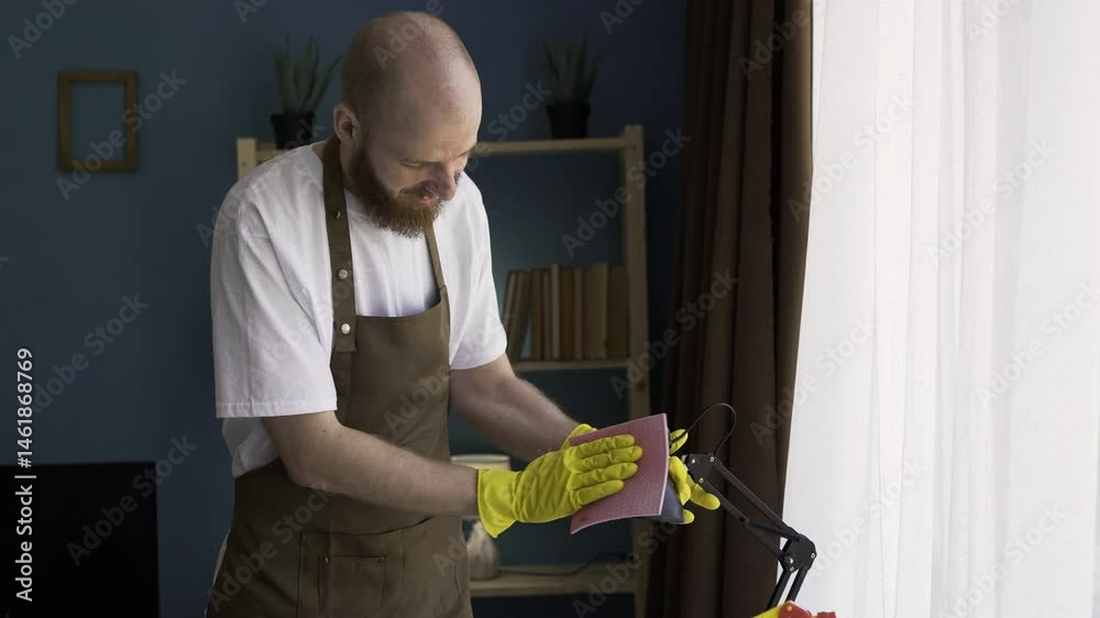 Male cleaner cleaning house dusting table lamp. Housework and house cleaning concept Male cleaner cleaning house dusting table lamp. Housework and house cleaning concept
