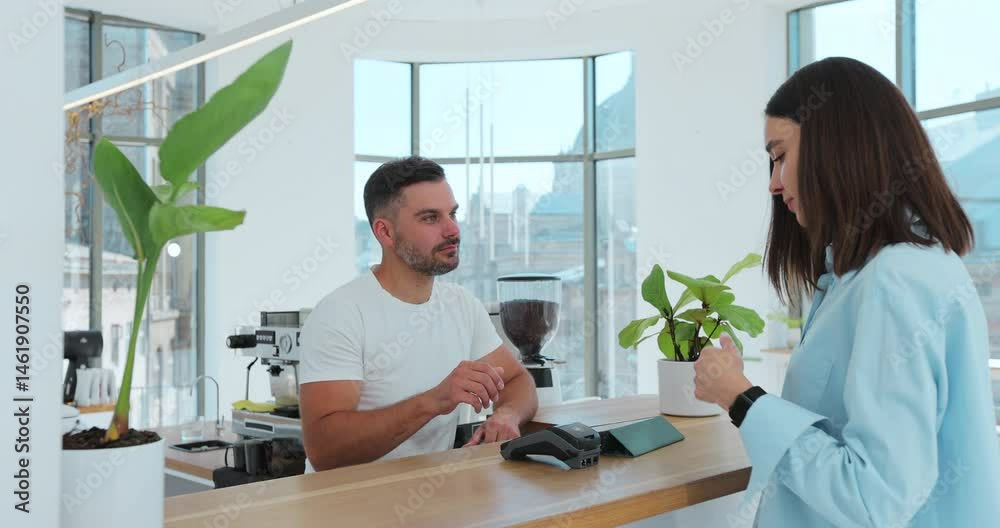 Customer paying with an NFC contactless smartwatch with a card machine. Paying in a coffee shop by a smartwatch. Technology. Customer paying with an NFC contactless smartwatch with a card machine. Paying in a coffee shop by a smartwatch. Technology.