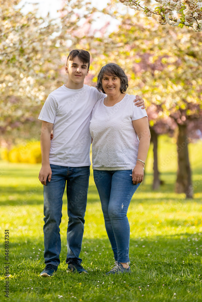 Portrait of cute stylish smiling family, boys and grandmother sitting in the grass in park Portrait of cute stylish smiling family, boys and grandmother sitting in the grass in park