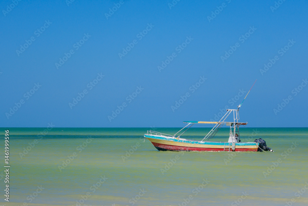 Fototapeta premium Colorful fishing boat floating in shallow Caribbean waters