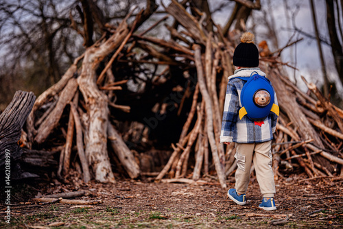 Child Exploring Wooden Stick Fort in Forest