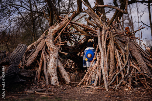 Child Exploring Wooden Stick Fort in Forest