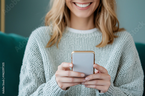 close up of smiling woman using smartphone while sitting on couch, showcasing cozy atmosphere and modern technology. Her joyful expression adds warmth to scene
