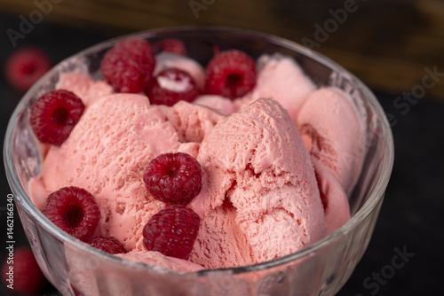 ice cream in a glass, sweet frozen red ice cream with raspberry flavor closeup, dessert in a clear glass