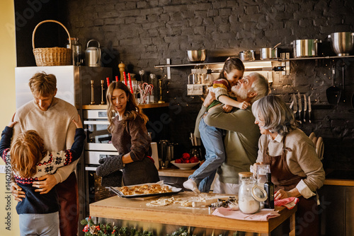 Fotografía A multigenerational family gathers in a festive kitchen to bake together for Christmas