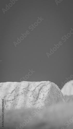 Bottle of perfume is shown on a rocky surface. The bottle is black and has a black cap. The bottle is placed on a rock, and the rock is surrounded by other mossy rocks. Premium photo 3d render.