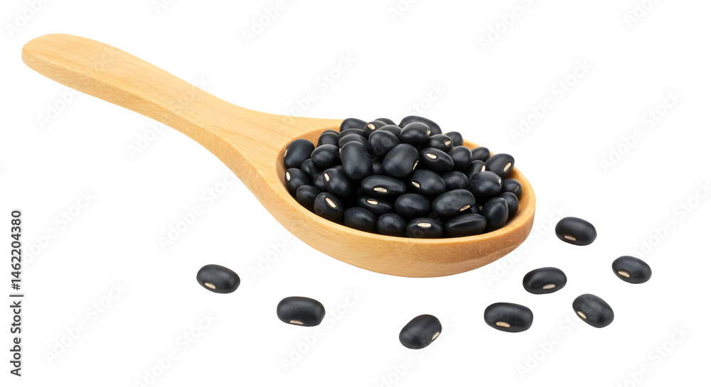 A wooden spoon overflowing with black beans, some spilling onto a dark background.
