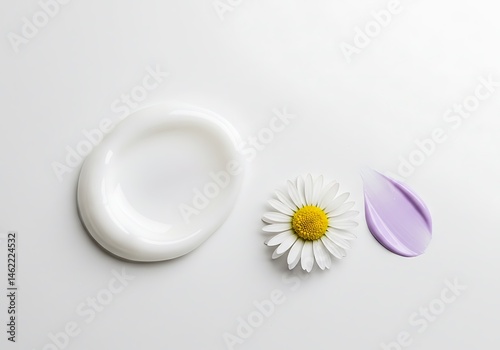 White cream smear with a daisy flower and a purple cream smear on a white surface background