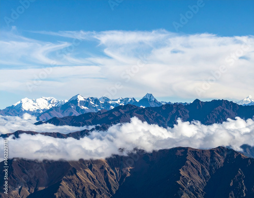 A view of the majestic Andes Mountains with layers of clouds hovering above peaks.