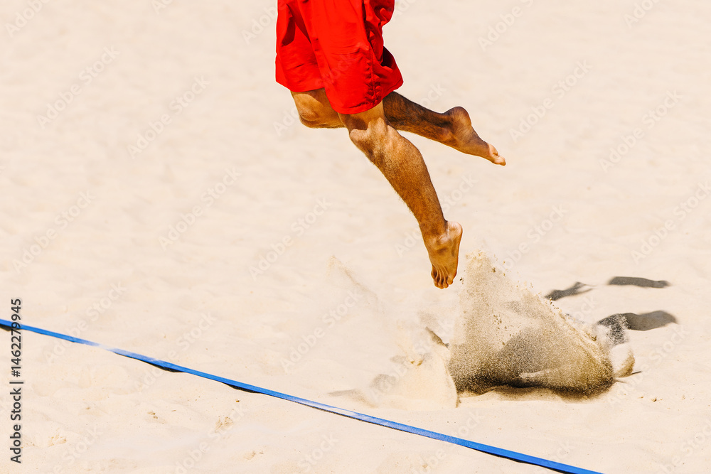 Beach volleyball, summer sports. Legs of a volleyball player in a lunge when serving behind the baseline. Beach sand