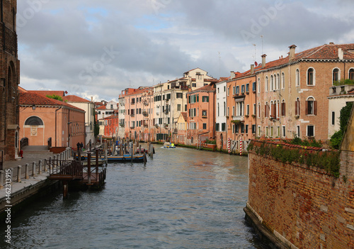wide waterway with more moored boats and houses in Venice in Northern Italy