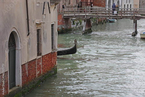 Obraz na płótnie Bow of Gondola boat behind the corner of and houses on the navigagle waterway in Venice Island in Italy w salonie