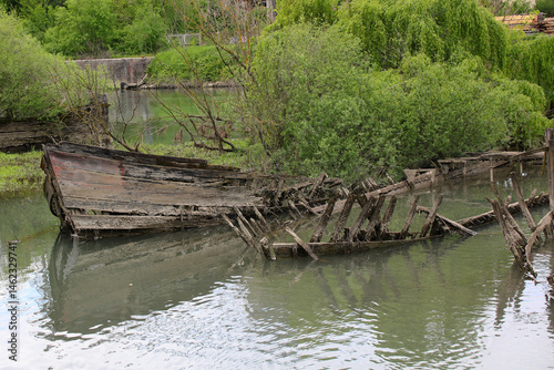 Obraz na płótnie Bow of th sunken old ship called BURCIO or BURCHIO in italian language in the BURCI CEMETERY a suggestive place in the bend of the river SILE in Northern Italy with wrecks of old sunken wooden boats w salonie