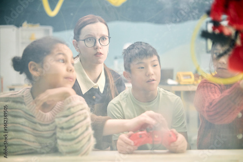 Tapet Multiracial children engaging in classroom activity with teacher observing close