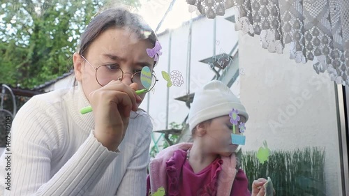 Two girls draw and wash the drawings off the window glass.
