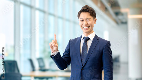 人差し指を立てて案内する男性ビジネスマン