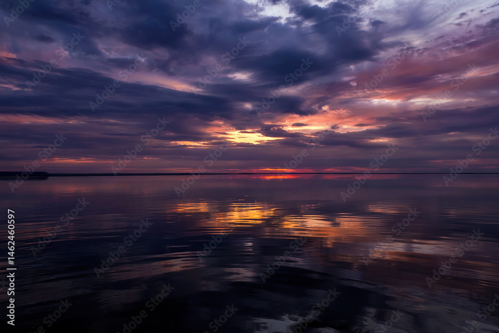 Fototapeta premium Evening landscape with a pond and cloudy sky.