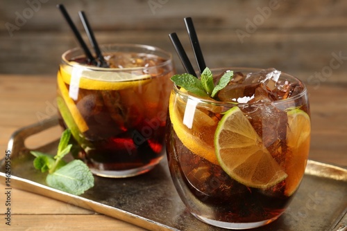 Photography Refreshing Cuba libre cocktail with mint on wooden table, closeup