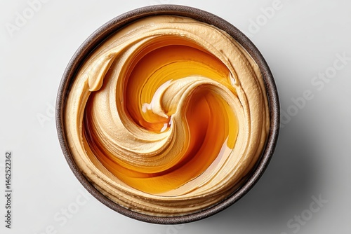 Close-up view of creamy peanut butter and honey swirled together. Rich textures and appetizing colors create an inviting and delicious scene indoors during daytime.
