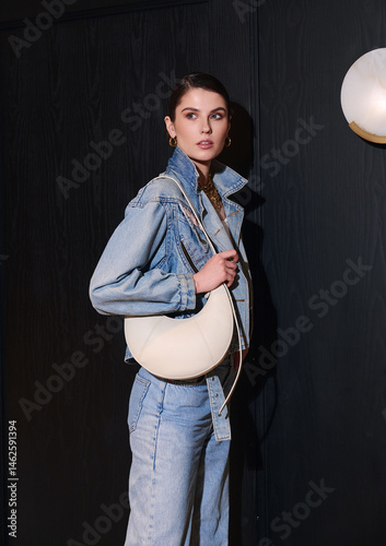 Schilderij op canvas Girl model in the interior in stylish clothes with a bag