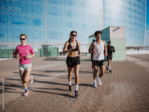 Obraz na płótnie Group of six athletes running and smiling while looking ahead, outdoors w salonie