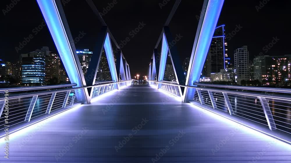 Illuminated bridge at night over water.