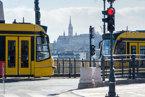 Distant view of Matthias church between two trams on Margaret bridge
