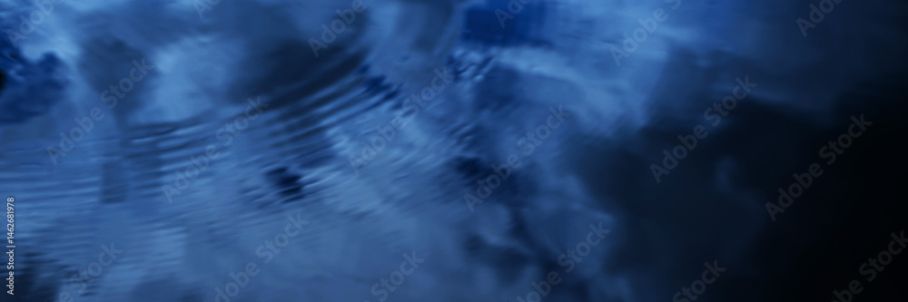 Black dark blue lake water surface abstract background. Reflection of sky and white clouds. Abstract. Ripples. Night evening. Dramatic cloudy. Design. Wide banner. Panoramic.