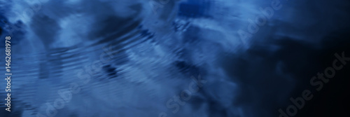 Obraz na płótnie Black dark blue lake water surface abstract background. Reflection of sky and white clouds. Abstract. Ripples. Night evening. Dramatic cloudy. Design. Wide banner. Panoramic. w salonie