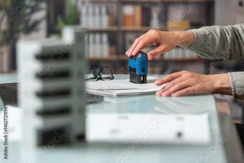 Female hand puts a stamp on a real estate deal
