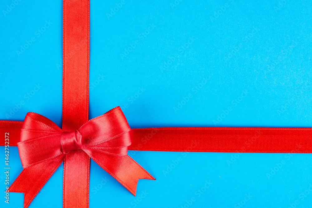 Red ribbon and bow on blue background