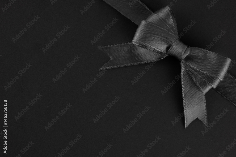 Black ribbon and bow on black background