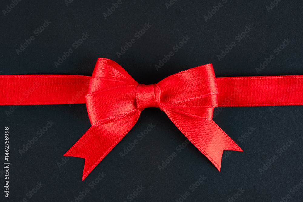 Red ribbon and bow on black background