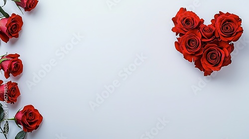 Red roses arranged in a heart shape on a light gray background.