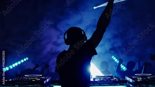 Silhouette of a DJ at a vibrant club, shot from behind at eye level. Colorful lights and smoke create a dynamic video party atmosphere.