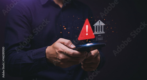 A person holding a phone with a red warning sign and bank icon hovering above the screen image  real estate business ,technology ,selling ,purchasing ,agreement