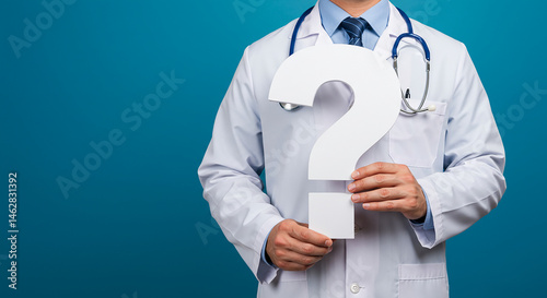 Doctor in white coat holding a question mark against a blue background in a studio setting  real estate business ,technology ,selling ,purchasing ,agreement