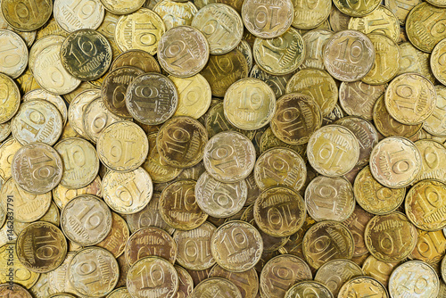 Pile of Ukrainian 10 kopiyok coins, symbolizing economy, finance, and savings.