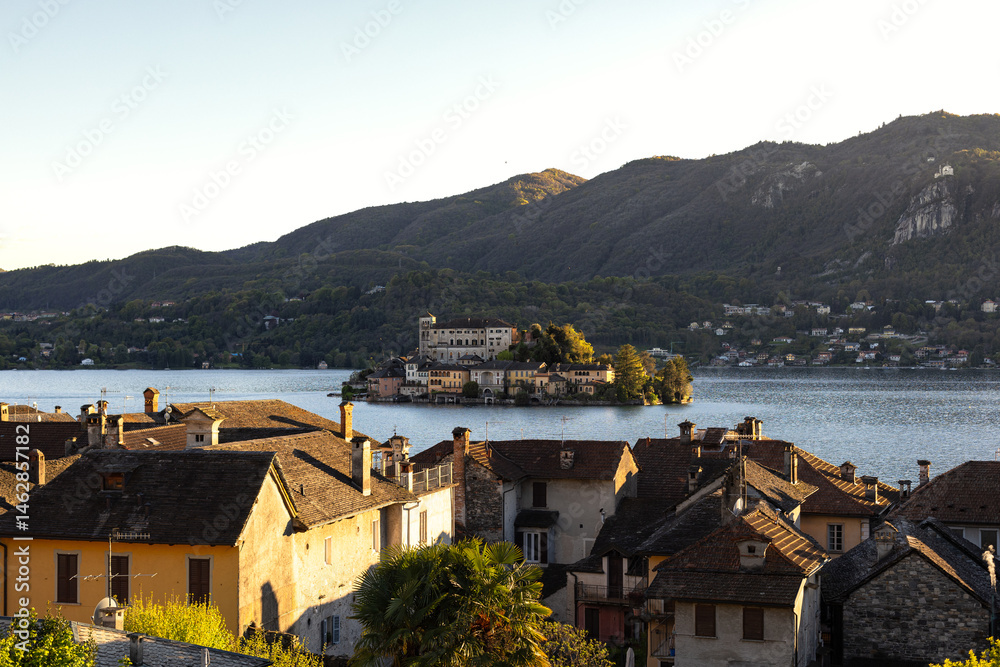 Fototapeta premium High angel view of San Giulio Island on the Lake Orta in a springtime, april 2025, Piedmont, Italy. Basilica di San Giulio. Benedictine monastery.