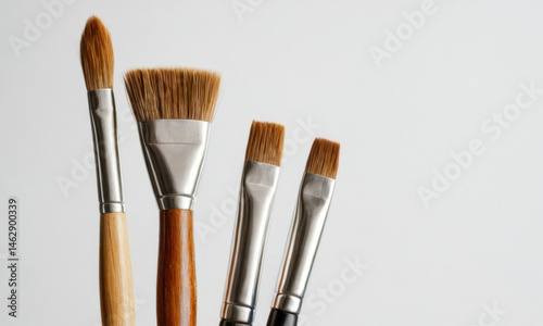 A collection of paintbrushes arranged neatly on a wooden table, ready for artistic use