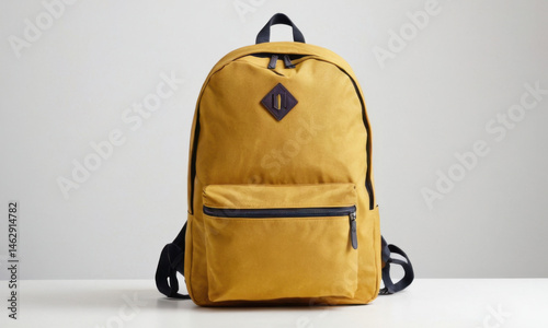 Obraz na płótnie A single yellow backpack sitting on a white table, a simple scene with no additional objects or distractions w salonie