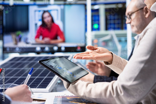 Factory experts design assembly facility production lines in tablet CAD program in videoconference. Employees use software on device to optimize factory production layouts in internet videocall