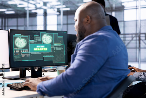 Obraz na płótnie Access granted notification on monitor received by man reconfiguring server hub, optimizing it. African american data center IT expert using PC to successfully eliminate all errors w salonie