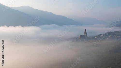 Autumn morning fog over Danube river hyperlapse Weisenkirchen in der Wachau town and vineyards. Wachau valley, Austria.