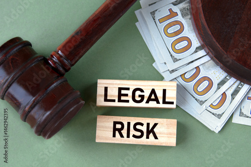 LEGAL RISK - words on wooden blocks against the background of a judge's gavel and banknotes