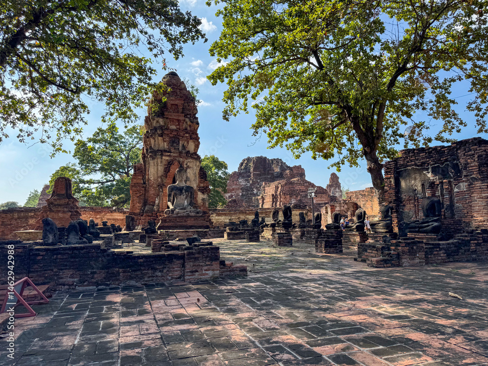 Spiritual Buddha statues outdoors at the old Thai temple landmark, Wat Maha That tourism. Ancient historical brick structures symbolizing peace and spirituality, famous Buddhist culture.