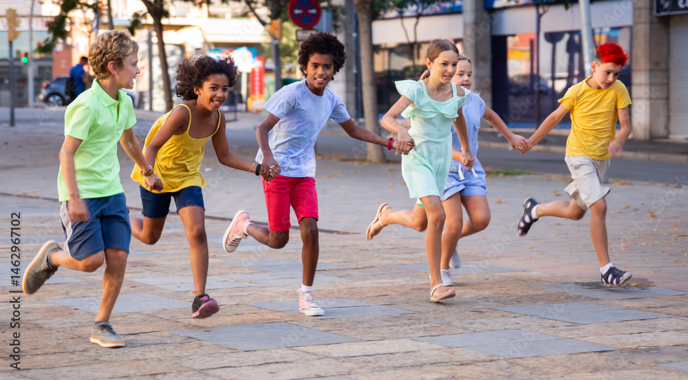 Obraz premium Group of smiling kids holding each other hands while running through city streets together.