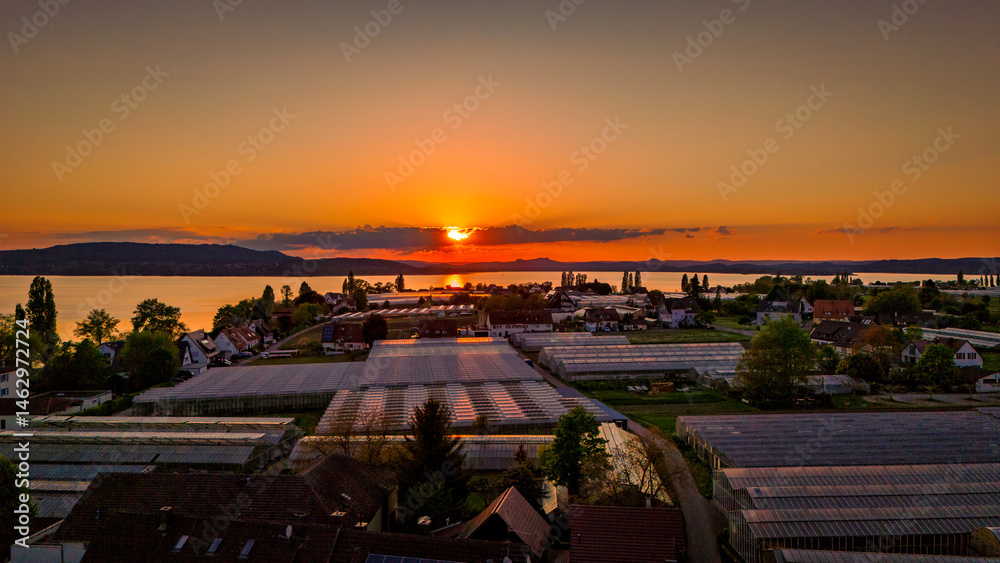 Aerial view over Reichenau Island in Lake Constance with large gardening greenhouses and sundown, Baden-Württemberg, Germany