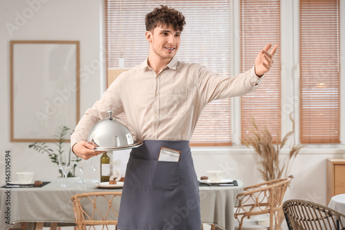 Male waiter with cloche in ...