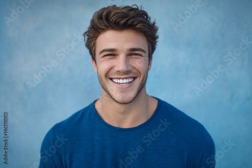 Young caucasian male smiling with blue background